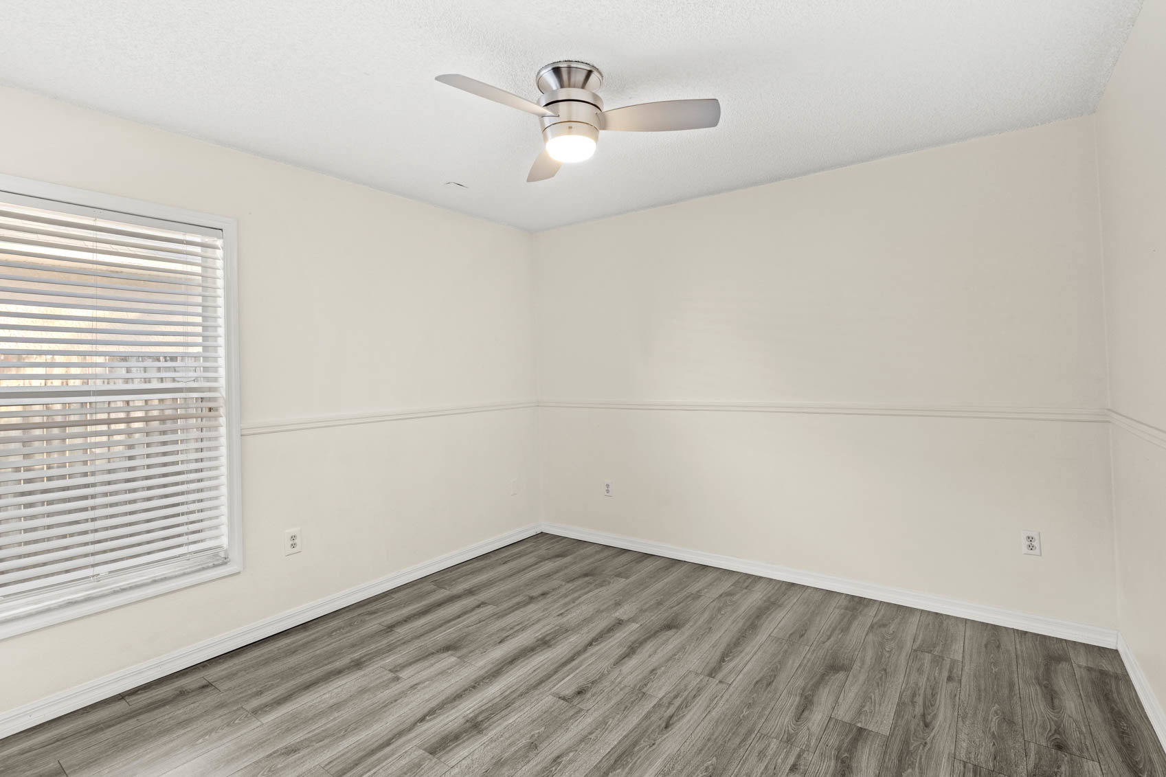 bedroom with grey wooden floors and yellow walls